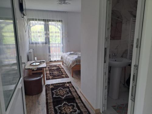 Un dormitorio con una cama y un lavabo en una habitación. en Căsuța din livadă, en Capu Cîmpului