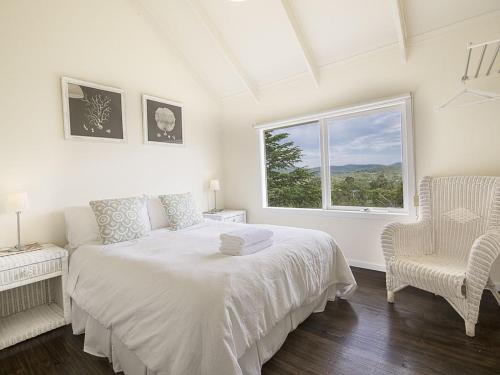 Una habitación blanca con una cama y una ventana en Healesville Country House, en Healesville