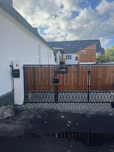 a fence in front of a house with a wooden gate at F5 - 2 Zimmer Wohnung in Offenbach