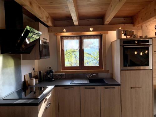 eine kleine Küche mit Spüle und Fenster in der Unterkunft Chalet individuel en montagne in La Forclaz