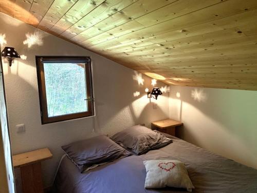ein Bett in einem Zimmer mit Holzdecke in der Unterkunft Chalet individuel en montagne in La Forclaz