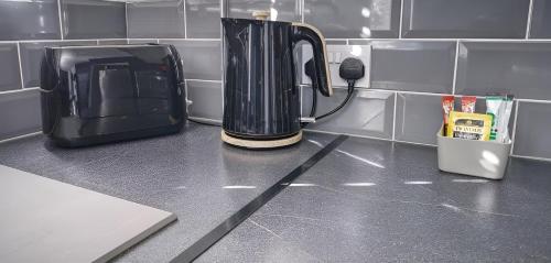 a kitchen counter with a blender on a counter top at Cosy Apartments for Couples & Working Professionals Free Parking & Smart TV in Derby