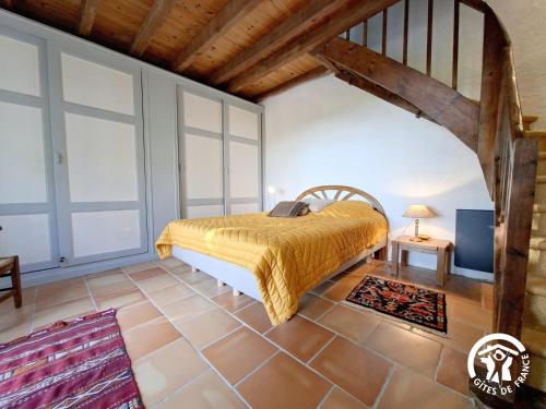- une chambre avec un lit et une couette jaune dans l'établissement Peyres, à Mansencôme