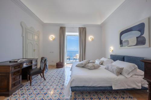a bedroom with a bed and a desk and a window at Dimora de Feo in Amalfi