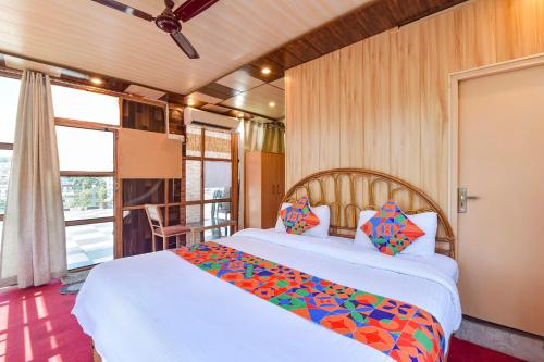 FabHotel Doon Classic Homestay في دهرادون: غرفة نوم مع سرير كبير وشرفة
