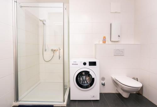 a bathroom with a washing machine and a toilet at 306 London 59m2 4-8 Pers extra Bedroom in Klagenfurt