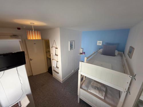 a bedroom with a white bed and blue walls at The Badger Inn in Carbis Bay