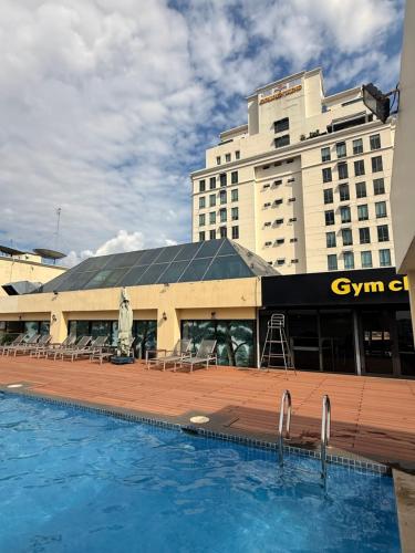 a hotel with a swimming pool in front of a building at Hygge Haven Saigon in Ho Chi Minh City