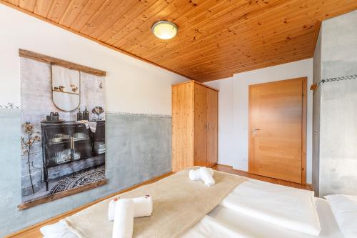 een slaapkamer met een bed en een houten plafond bij BioHAUS in Haus im Ennstal