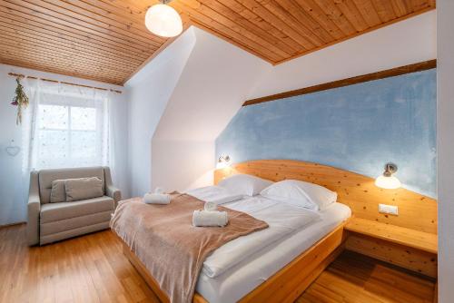 een slaapkamer met een groot bed en een stoel bij BioHAUS in Haus im Ennstal