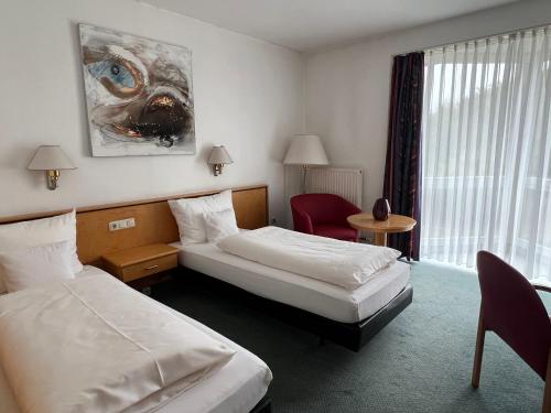 a hotel room with two beds and a window at Matchpoint Hotel in Altdorf bei Nuernberg