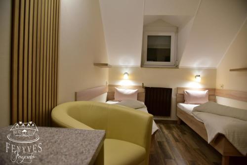 a hotel room with two beds and a couch at Fenyves fogadó in Ásotthalom