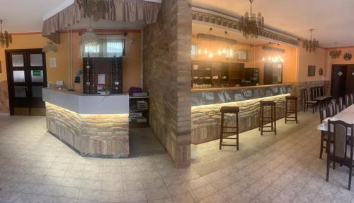 a bar in a restaurant with chairs and tables at Fenyves fogadó in Ásotthalom