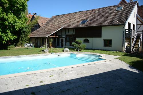 a swimming pool in front of a house at La Passerelle de la Doller in Reiningue