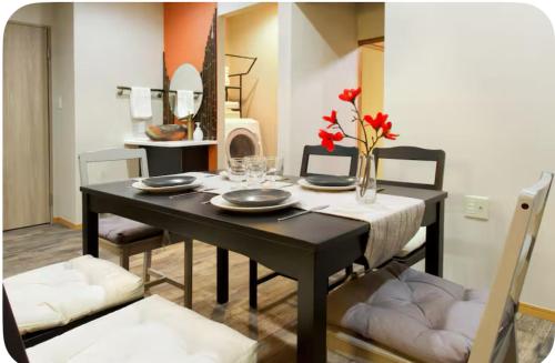 Un comedor con una mesa y sillas negras. en 楓の宿1號館, en Osaka