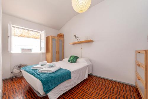 ラゴスにあるCasa dos Peixeiros in Lagosのベッドとタオル2枚のある寝室