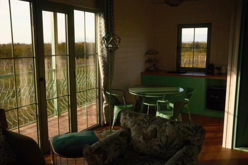 a living room with a table and chairs and windows at Chateau Vartsikhe in Varts'ikhe