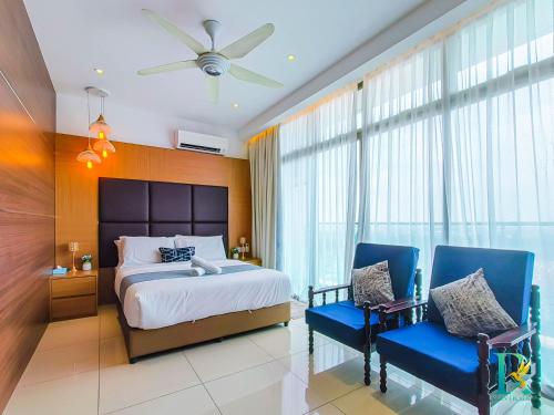 een slaapkamer met een bed en twee blauwe stoelen bij Palazio Serviced Apartments by RR JBcity in Johor Bahru