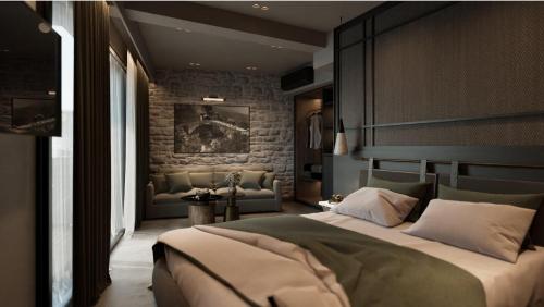 a bedroom with a large bed and a stone wall at Alkioni Boutique Hotel in Pýli