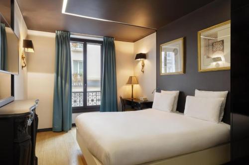 a bedroom with a large white bed and a window at New Hotel République in Paris