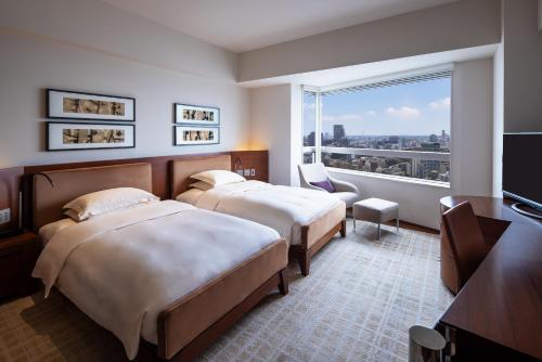 a hotel room with two beds and a large window at Grand Hyatt Tokyo in Tokyo