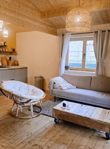 a living room with a couch and a table at Chalet romantique & bucolique in Montignac-Charente