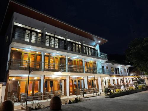 a lit up building with a balcony at night at Sebay Surf Central San Juan La Union in San Juan