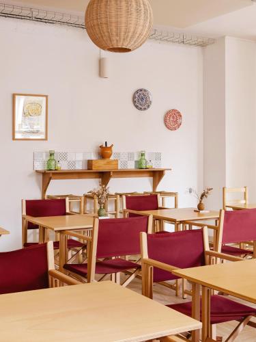 Un comedor con mesas de madera y sillas moradas. en ALFRED HOTELS Compiègne, en Compiègne