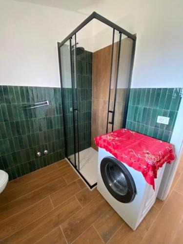 a washing machine with a red table in a bathroom at Vila Blue River in Orikum