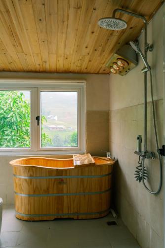 a large wooden tub in a bathroom with a window at The Flow Homestay in Sapa