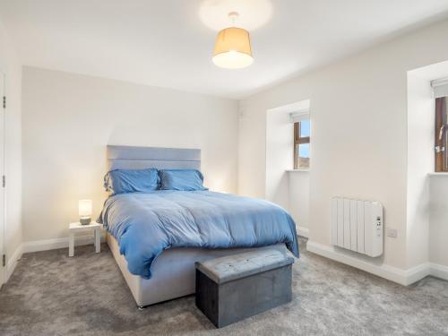 a bedroom with a bed with a blue comforter at 17 Clifden Court in Clifden