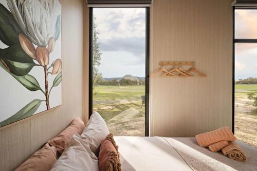 a bedroom with a bed with a large window at Hollow Mountain Getaway 2 by Tiny Away in Laharum