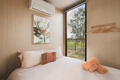 a bedroom with a white bed and a window at Hollow Mountain Getaway 2 by Tiny Away in Laharum