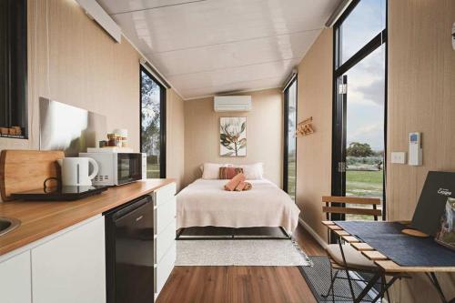 a small bedroom with a bed in a tiny house at Hollow Mountain Getaway 2 by Tiny Away in Laharum