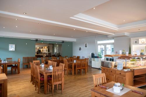 Un comedor con mesas y sillas de madera. en Aparthotel Seepanorama, en Mirow