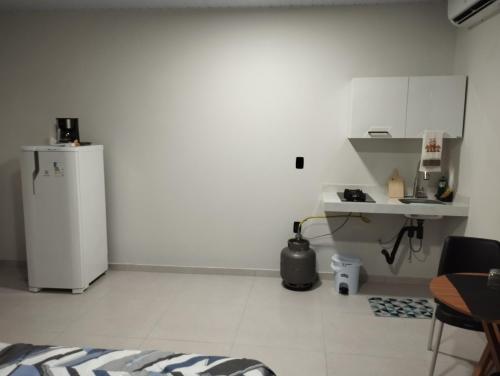 een witte keuken met een koelkast en een tafel bij Comfortable studio, well located in Macapá