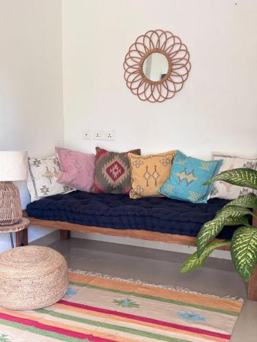 eine Couch mit Kissen darauf in einem Zimmer in der Unterkunft Drifters Surf Eat Stay in Kappil