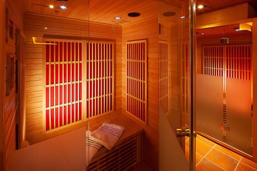 a sauna with a glass shower stall with a towel at Alpine Lifestyle Berghotel Madlener in Damuls