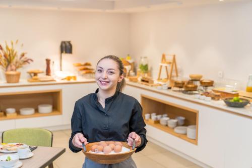 une femme tenant un bol d'œufs dans une cuisine dans l'établissement Trofonios Boutique Hotel, à Lébadée