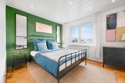 a bedroom with a bed and a green wall at Cosmic Living by Tayo Ajayi in Zwickau