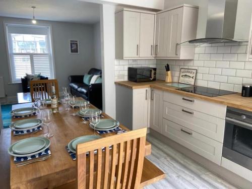 a kitchen with a table with plates on it at Oyster Catchers in Ryde