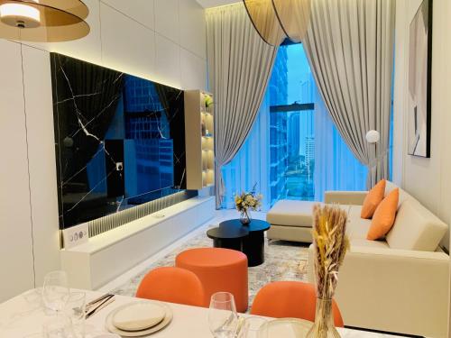 a living room with orange chairs and a couch at Eaton Residences By Classic in Kuala Lumpur