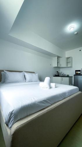 a large white bed with white sheets in a room at Modern Comfort Studio with City Views in Molo