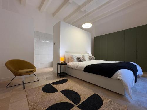 a bedroom with a bed and a chair and a rug at St Ursula Sanctuary 3 Bed Valletta in Valletta