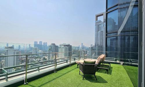 a balcony with a chair on top of a building at Hyatt Regency Bangkok Sukhumvit in Bangkok