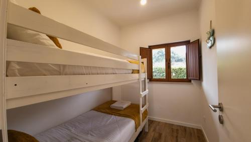 zwei Etagenbetten in einem Zimmer mit Fenster in der Unterkunft Casa Rosa, Quinta Carmo - Alcobaça/Nazaré in Alcobaça