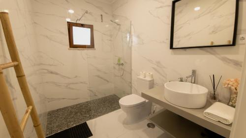 ein weißes Badezimmer mit Waschbecken und Toilette in der Unterkunft Casa Rosa, Quinta Carmo - Alcobaça/Nazaré in Alcobaça