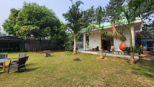 a house with a yard with a table and chairs at Saanjh Farm in Gurgaon