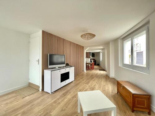 a living room with a television on a white cabinet at Le Cosy Tranchais - city center - 300 m beach in La Tranche-sur-Mer