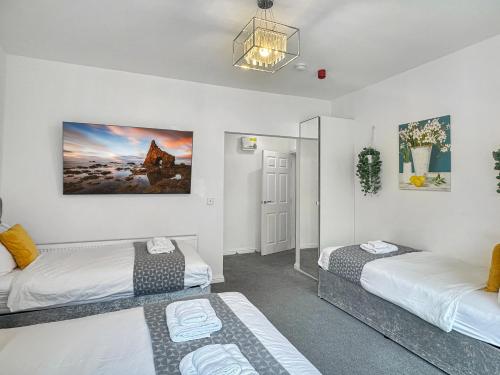 a bedroom with two beds and a potted plant at Granada Apartments at Pleasure Beach in Blackpool